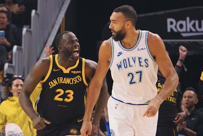 Nov 12, 2023; San Francisco, California, USA; Golden State Warriors forward Draymond Green (23) celebrates behind Minnesota Timberwolves center Rudy Gobert (27) after scoring a three point basket during the first quarter at Chase Center.